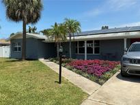 Charming home with well-maintained lawn, beautiful flower beds, solar panels, and inviting walkway at 4301 50Th S Ter, St Petersburg, FL 33711