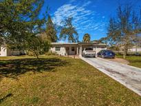 Charming single-story home featuring a well-manicured front yard, driveway, and two parked cars at 7101 8Th N Ave, St Petersburg, FL 33710