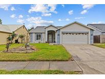 Charming single-story home featuring a two-car garage and well-maintained front yard at 1489 Ridge Shore Dr, Tarpon Springs, FL 34689