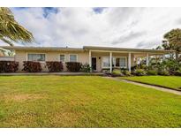 Inviting single-story home with a well-maintained lawn and covered porch, perfect for relaxing outdoors at 2340 W Bay Isle Se Dr, St Petersburg, FL 33705