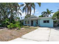 Charming single-story home with mature trees and a concrete driveway at 300 Westwinds Dr, Palm Harbor, FL 34683