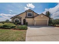 Charming two-story home with stone accents, three-car garage, and manicured landscaping at 3303 Ranchdale Dr, Plant City, FL 33566