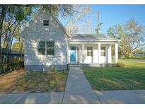 Charming home featuring a bright blue front door and inviting covered porch at 6401 N 47Th St, Tampa, FL 33610