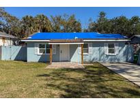 Charming single-story home with a bright blue tarp on the roof, white shutters, and a well-maintained front yard at 6708 S Faul St, Tampa, FL 33616