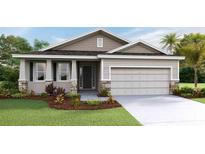 Charming single-story home with a two-car garage, manicured lawn, and neutral-toned siding at 7795 Wheat Stone Dr, Zephyrhills, FL 33540