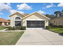 Charming single-story home with a well-manicured lawn and a spacious screened two-car garage at 11321 Copley Ct, Spring Hill, FL 34609