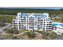 Stunning multi-story condo with blue accents, lush landscaping, and circular driveway at 2333 Feather Sound Dr # A308, Clearwater, FL 33762