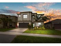 Beautiful two-story home with manicured lawn, landscaped garden, and a paved driveway leading to a two-car garage at 3107 Mountain Spruce Ter, Wesley Chapel, FL 33543