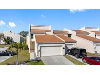 Charming townhouse features a well-manicured lawn, private driveway, and durable metal roof at 4358 Outrigger Ln, Tampa, FL 33615