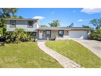Charming split-level home boasting a well-manicured lawn and inviting stone walkway, adding to its curb appeal at 500 Hillpine Way, Brandon, FL 33510