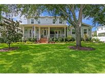 Charming two-story home featuring a spacious front porch, well-manicured lawn, and beautiful landscaping at 5024 W Homer Ave, Tampa, FL 33629