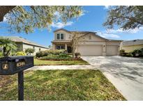 Charming two-story home featuring a spacious three car garage and a manicured lawn at 6308 Bridgevista Dr, Lithia, FL 33547