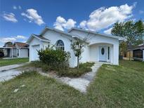 Charming single-story home featuring stucco siding, an attached garage, and mature landscaping at 8229 Riverboat Dr, Tampa, FL 33637