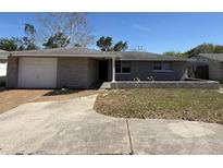 Charming single-story home with a well-maintained lawn and attached garage, exuding curb appeal at 8708 Robilina Rd, Port Richey, FL 34668