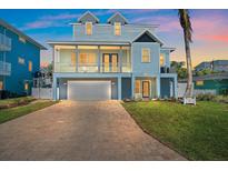 Charming two-story coastal home with a brick driveway, large garage, and a welcoming front porch at 112 79Th St # B, Holmes Beach, FL 34217