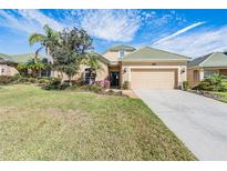Charming single-story home featuring a well-manicured lawn and an attached two-car garage at 13247 Palmilla Cir, Dade City, FL 33525
