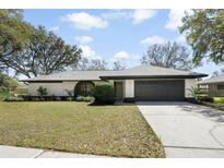 Charming single-story home with a well-maintained lawn, two-car garage, and beautifully landscaped front yard at 15921 Wyndover Rd, Tampa, FL 33647