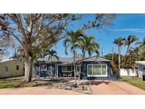 Charming single story home with mature landscaping, including palm trees, and a welcoming front porch at 1859 Oklahoma Ne Ave, St Petersburg, FL 33703