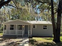 Charming single story home with a welcoming front porch and mature tree shading the property at 203 D Street, Brooksville, FL 34601