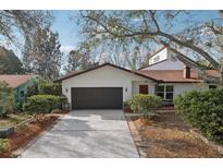 Charming single-Gathering home featuring a two-car garage, well-kept landscaping, and a cozy front entrance at 2213 Spanish Vistas Dr, Dunedin, FL 34698