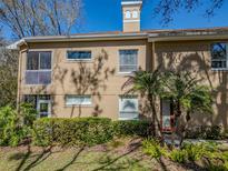 Charming condo exterior with a manicured lawn and tropical landscaping, creating a welcoming curb appeal at 4266 Preserve Pl # 4266, Palm Harbor, FL 34685