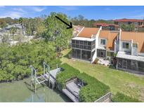 View of the backyard featuring a dock, boat lift, waterfront access, and screened-in porch at 4312 Sunray Ct # 36, Tampa, FL 33615