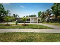 Charming single-story home with a well-manicured lawn, palm trees, and a long driveway on a sunny day at 4500 22Nd S Ave, St Petersburg, FL 33711