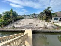 View of a waterfront lot with wooden dock ready for your custom home at 5105 W Longfellow Ave, Tampa, FL 33629