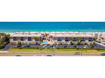 Stunning aerial view of beachfront condos with a pool, parking, and access to the beautiful ocean at 3100 Gulf Blvd # 134, Belleair Beach, FL 33786