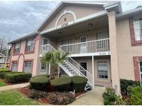 Condo exterior showing landscaped entrance and two story units with a balcony at 4739 Myrtle Oak Dr # 21, New Port Richey, FL 34653