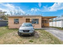 Front exterior showcasing a cozy single-story home with a car parked out front on a sunny day at 2501 Auburn S St, St Petersburg, FL 33712