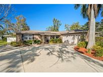 Charming single-story home with a well-manicured lawn, mature landscaping, and a spacious driveway leading to a two-car garage at 3051 37Th S Ave, St Petersburg, FL 33712