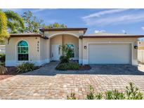 Charming single-story home featuring a brick driveway, arched entryway, and an attached two-car garage at 3111 Park N St, St Petersburg, FL 33710