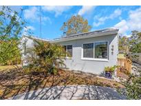 Charming home exterior featuring light-colored stucco, a well-kept yard, and beautiful landscaping at 356 Ridge Sw Rd, Largo, FL 33770