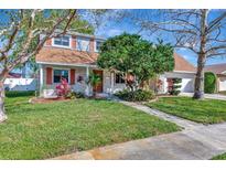 Charming two-story home with brick accents, lush landscaping, and a well-manicured lawn at 4711 Travertine Dr, Tampa, FL 33615