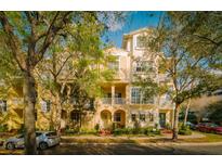 Charming townhome showcasing a light yellow color scheme, multiple balconies and lush, mature landscaping at 6030 Printery St # 107, Tampa, FL 33616