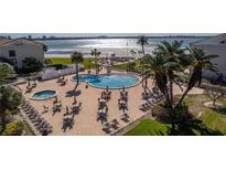Resort-style pool and patio with lounge seating, dining tables, and views of the Gulf of Mexico at 830 S Gulfview Blvd # 501, Clearwater Beach, FL 33767