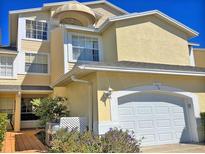 Inviting two-story home with attached garage and beautiful yellow stucco and siding under a sunny blue sky at 1050 Starkey Rd # 106, Largo, FL 33771