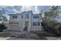 New construction two-story home featuring a modern design with stone accents, and an attached two-car garage at 1105 W Peninsular St, Tampa, FL 33603