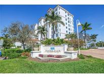 Exterior view of a white condominium building with lush landscaping and a decorative entrance sign at 1325 Snell Isle Ne Blvd # 611, St Petersburg, FL 33704