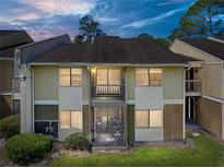 Inviting exterior of a multi-level condo with a balcony and a screened in porch overlooking a well-manicured lawn at 13385 Arbor Pointe Cir # 203, Tampa, FL 33617