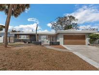 Charming single-story home featuring unique stone accents, a two-car garage and a well-manicured front yard at 2080 Attache Ct, Clearwater, FL 33764
