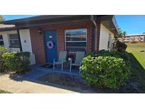Charming brick condo featuring a cozy front porch with a blue door and comfortable seating at 24862 Us Highway 19 N # 2906, Clearwater, FL 33763
