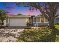 Charming single-story home with a well-manicured lawn and mature shade tree enhancing its curb appeal at 2519 Southern Oak Cir, Clearwater, FL 33764