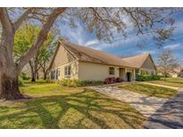 Charming single-story home with well-maintained lawn, mature trees and inviting curb appeal at 2847 Rampart Cir, Clearwater, FL 33761