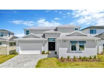 Elegant two-story home with a gray exterior, manicured lawn, and paved driveway leading to a two car garage at 32335 Wetland Bird Vw, San Antonio, FL 33576