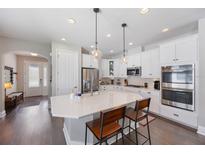 Bright kitchen featuring white cabinetry, stainless steel appliances, quartz countertops and a large kitchen island at 3991 Mellon Dr, Odessa, FL 33556