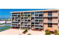 Exterior view of a multi-story condominium building with private balconies and marina views at 1 Key Capri # 604W, Treasure Island, FL 33706