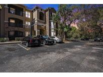 Multi-story condo building with stone facade and parking lot at dusk at 10017 Courtney Palms Blvd # 301, Tampa, FL 33619