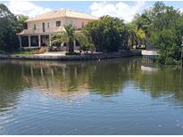 Stunning waterfront home featuring lush tropical landscaping and a beautiful terra cotta roof at 2107 S West Shore Blvd, Tampa, FL 33629